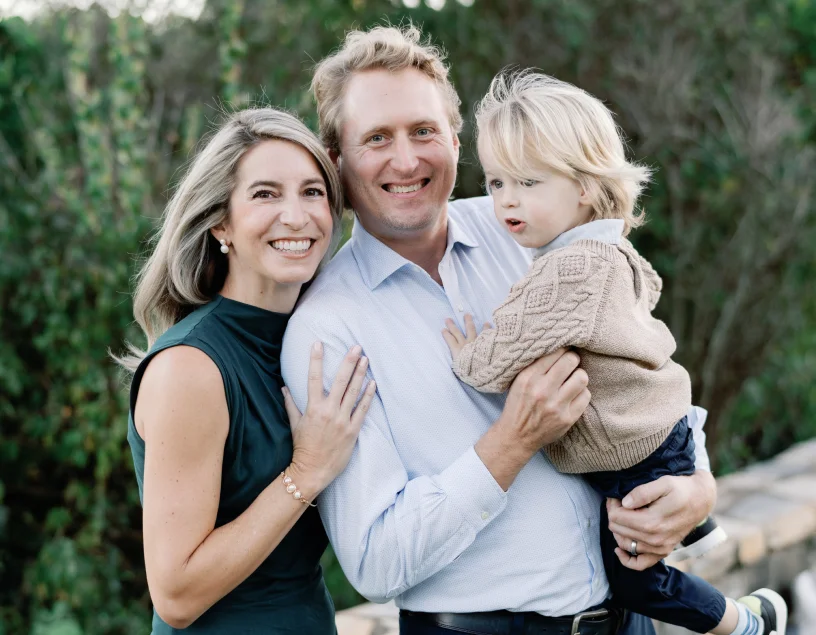 a man and woman holding a child