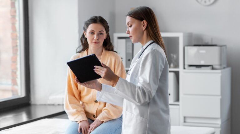 female doctor with tablet talking to woman patient