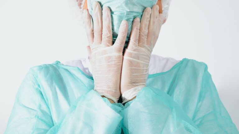 surgeon holds his head after surgery